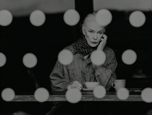 Woman at a diner counter beneath a row of bulb lights