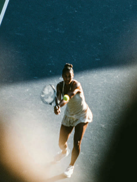 Tennis player returning a shot in low light