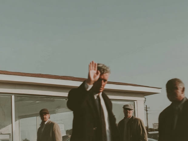 Man raising a hand on a rooftop deck