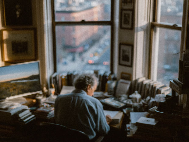 Writer at a desk before a window over the city